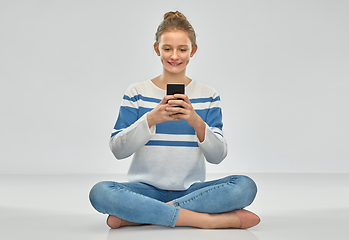 Image showing happy smiling teenage girl using smartphone