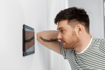 Image showing man looking at tablet computer at smart home