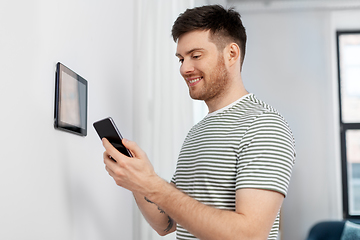 Image showing smiling man using tablet computer at smart home