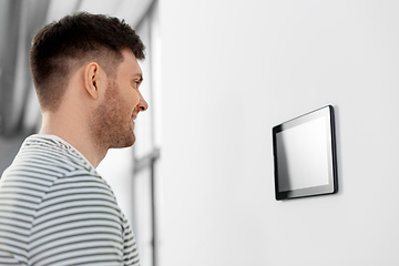 Image showing happy man looking at tablet computer at smart home