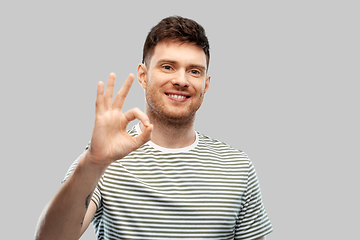 Image showing young man showing peace over grey background