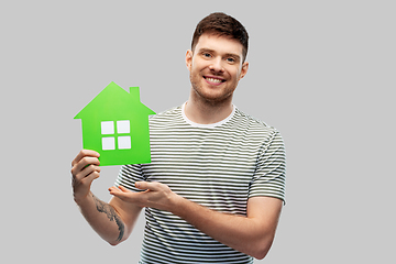 Image showing smiling young man holding green house icon