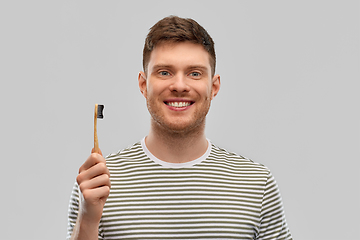 Image showing smiling man with wooden toothbrush