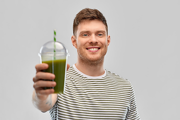 Image showing man drinking green smoothie from disposable cup