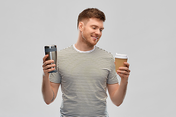 Image showing man comparing thermo cup or tumbler and coffee cup