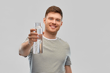 Image showing happy smiling man holding water in glass bottle