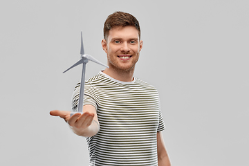 Image showing smiling young man with toy wind turbine