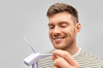 Image showing smiling young man with toy wind turbine