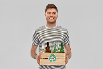 Image showing smiling young man sorting glass waste