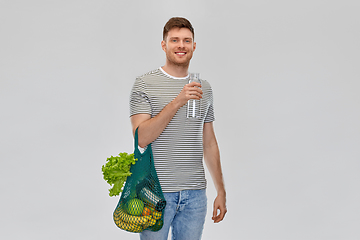 Image showing man with food in bag and water in glass bottle