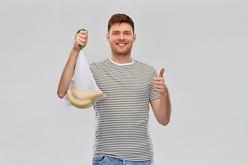 Image showing happy man holding reusable string bag with bananas