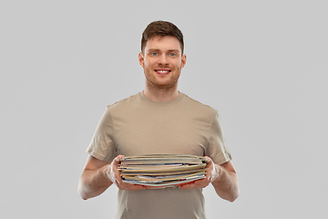 Image showing smiling young man sorting paper waste