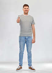 Image showing young man in striped t-shirt showing thumbs up