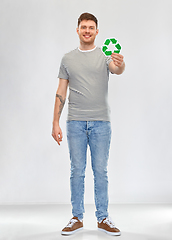 Image showing smiling young man holding green recycling sign