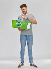 Image showing smiling young man sorting plastic waste