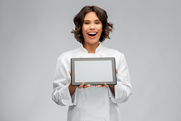 Image showing smiling female chef in toque with tablet computer