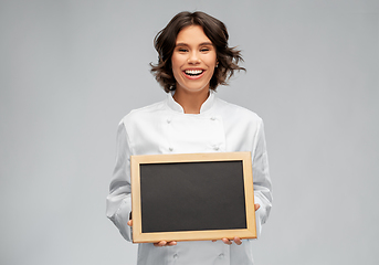 Image showing smiling female chef holding black chalkboard