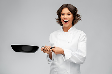 Image showing smiling female chef in toque with frying pan
