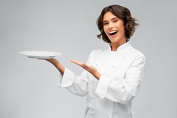 Image showing smiling female chef holding empty plate