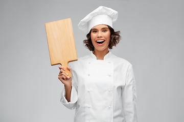 Image showing smiling female chef in toque with cutting board