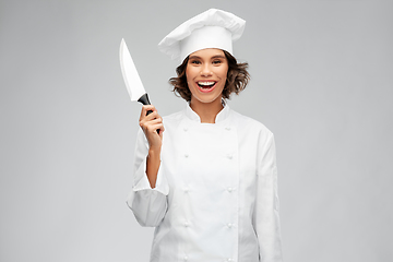 Image showing smiling female chef in toque with kitchen knife