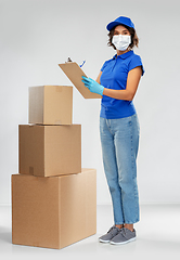 Image showing delivery woman in mask with boxes and clipboard