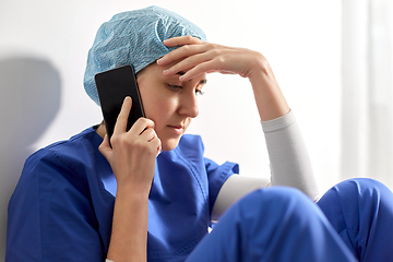 Image showing sad doctor or nurse calling on smartphone