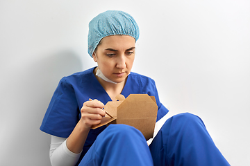 Image showing sad doctor or nurse eating takeaway food from box