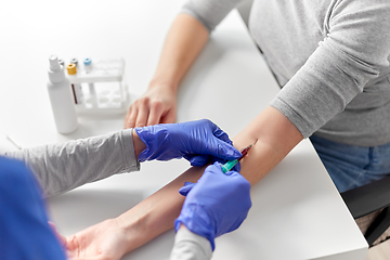 Image showing doctor taking blood for test from patient's hand