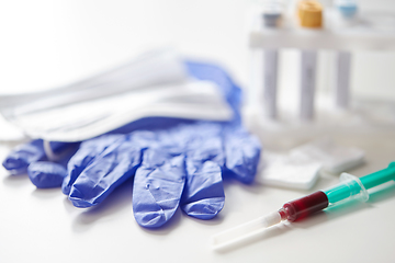 Image showing close up of blood in syringe, gloves and mask