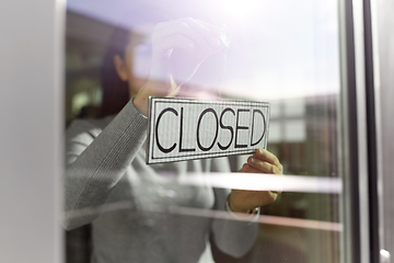 Image showing woman hanging banner with closed word on door