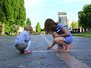 Image showing little sisters write on the road in the park