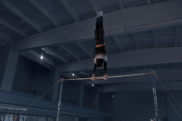 Image showing Little male gymnast training in gym, flexible and active