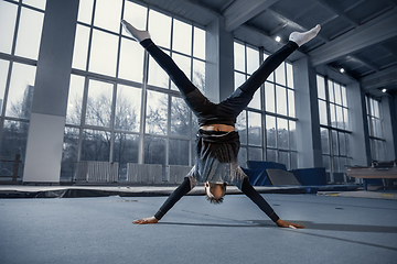 Image showing Little male gymnast training in gym, flexible and active