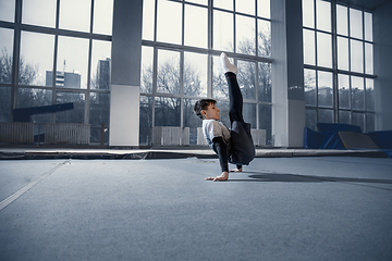 Image showing Little male gymnast training in gym, flexible and active