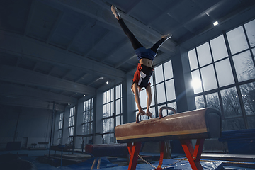 Image showing Little male gymnast training in gym, flexible and active