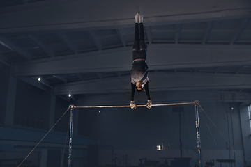 Image showing Little male gymnast training in gym, flexible and active