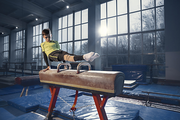 Image showing Little male gymnast training in gym, flexible and active