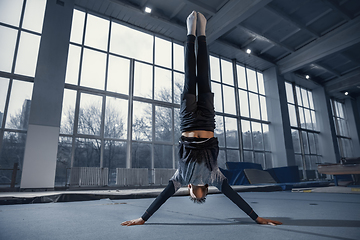 Image showing Little male gymnast training in gym, flexible and active