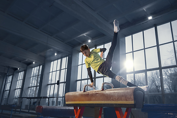 Image showing Little male gymnast training in gym, flexible and active