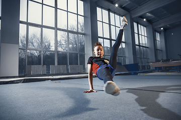 Image showing Little male gymnast training in gym, flexible and active