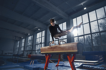 Image showing Little male gymnast training in gym, flexible and active