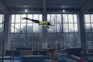 Image showing Little male gymnast training in gym, flexible and active