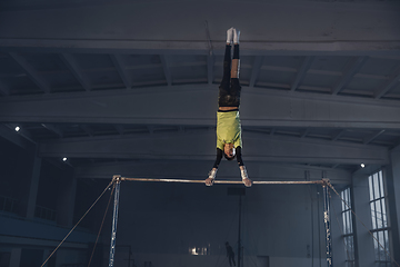 Image showing Little male gymnast training in gym, flexible and active