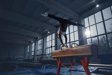 Image showing Little male gymnast training in gym, flexible and active