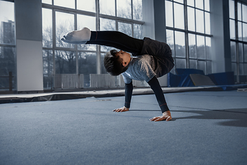 Image showing Little male gymnast training in gym, flexible and active