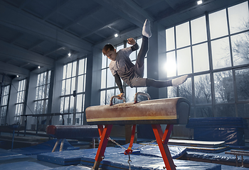 Image showing Little male gymnast training in gym, flexible and active