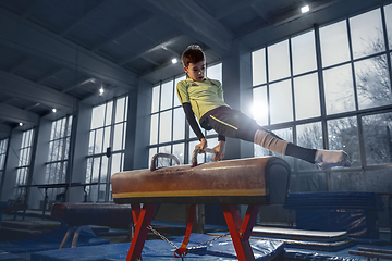 Image showing Little male gymnast training in gym, flexible and active