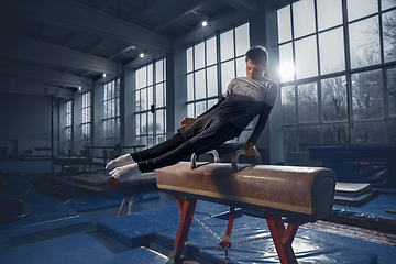 Image showing Little male gymnast training in gym, flexible and active