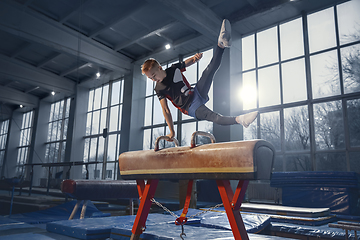 Image showing Little male gymnast training in gym, flexible and active